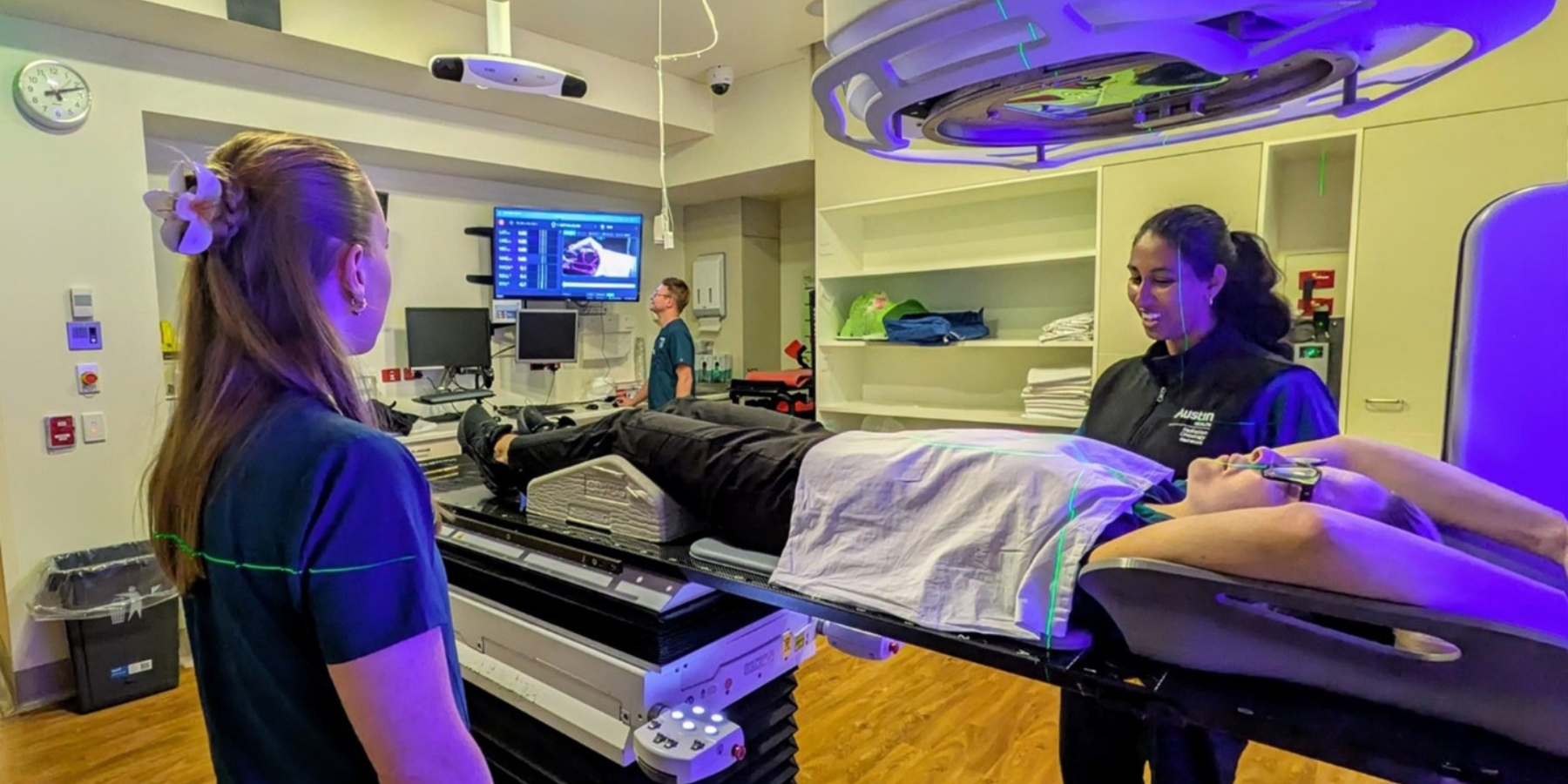 Picture of a patient receiving radiotherapy using the new method with nurses standing next to them